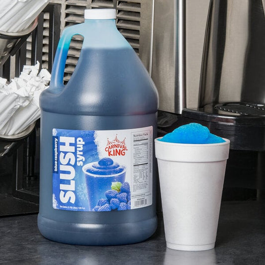 A blue jug of Carnival King Blue Raspberry slushy syrup next to a cup of blue slushy.