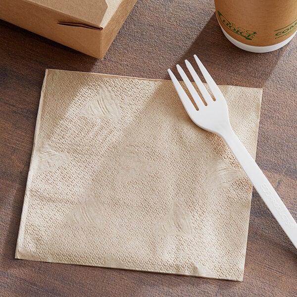 A plastic fork on a 12" x 12" natural kraft 1/4 fold luncheon napkin.