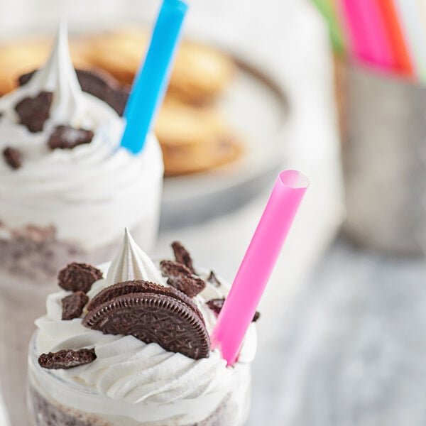 A milkshake with cookies and a pink Choice Colossal straw.
