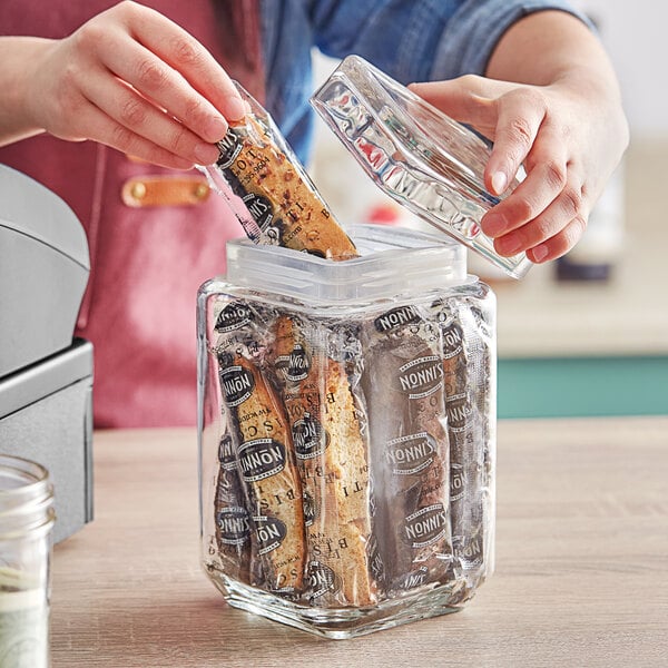 A person using an Acopa clear glass jar to store food.